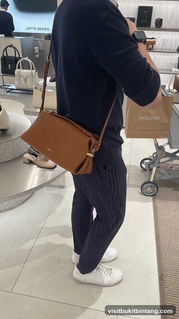 Person carrying a brown handbag in a store