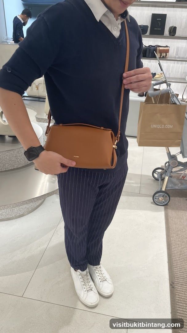 Person holding a brown handbag