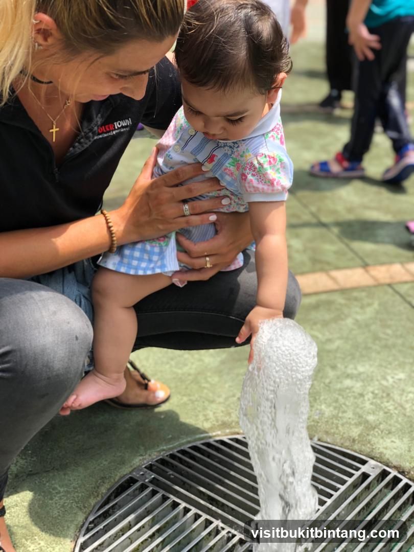 Woman holding a baby near a water fountain