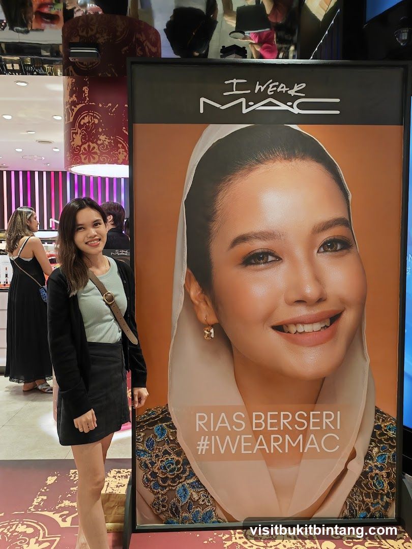 Woman Poses Next to MAC Cosmetics Advertisement
