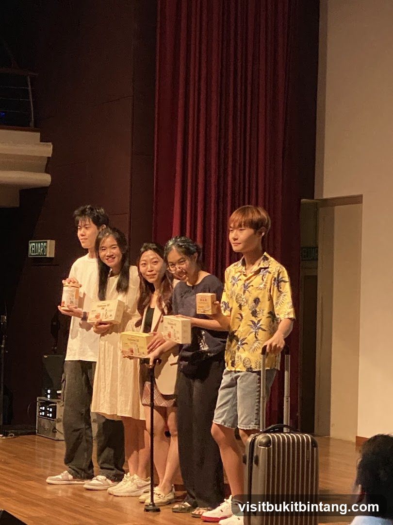 People on stage holding boxes