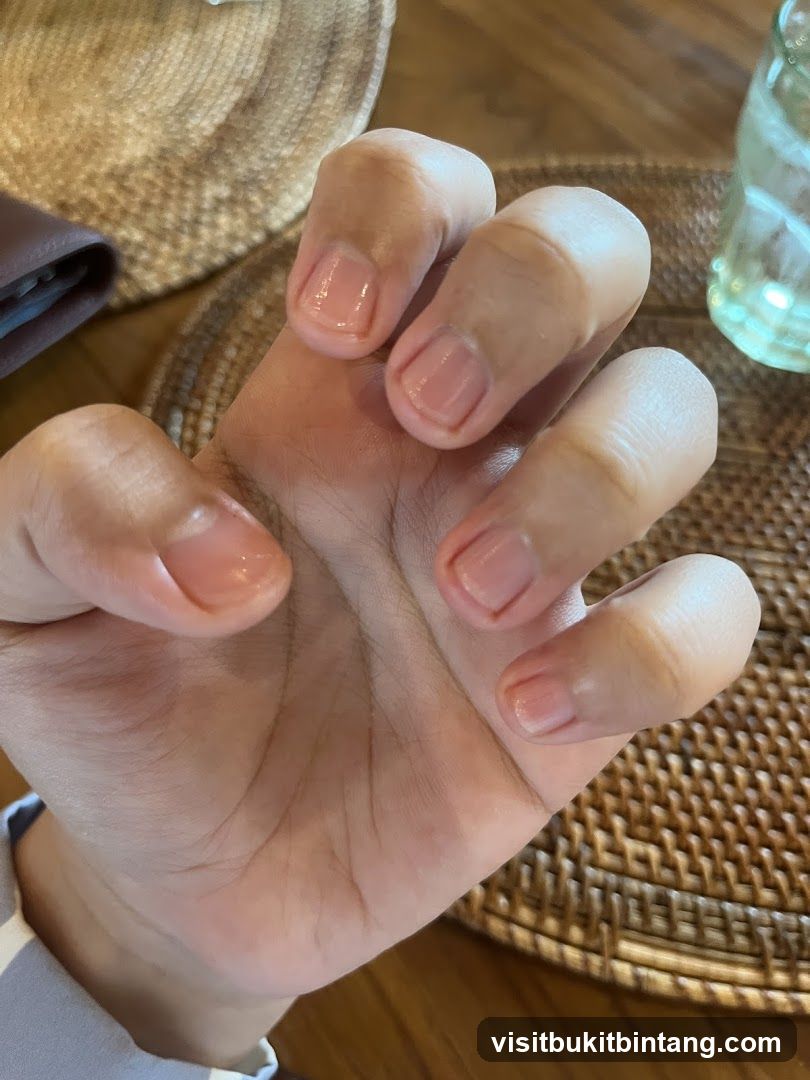 Close-up of a hand with light pink nail polish