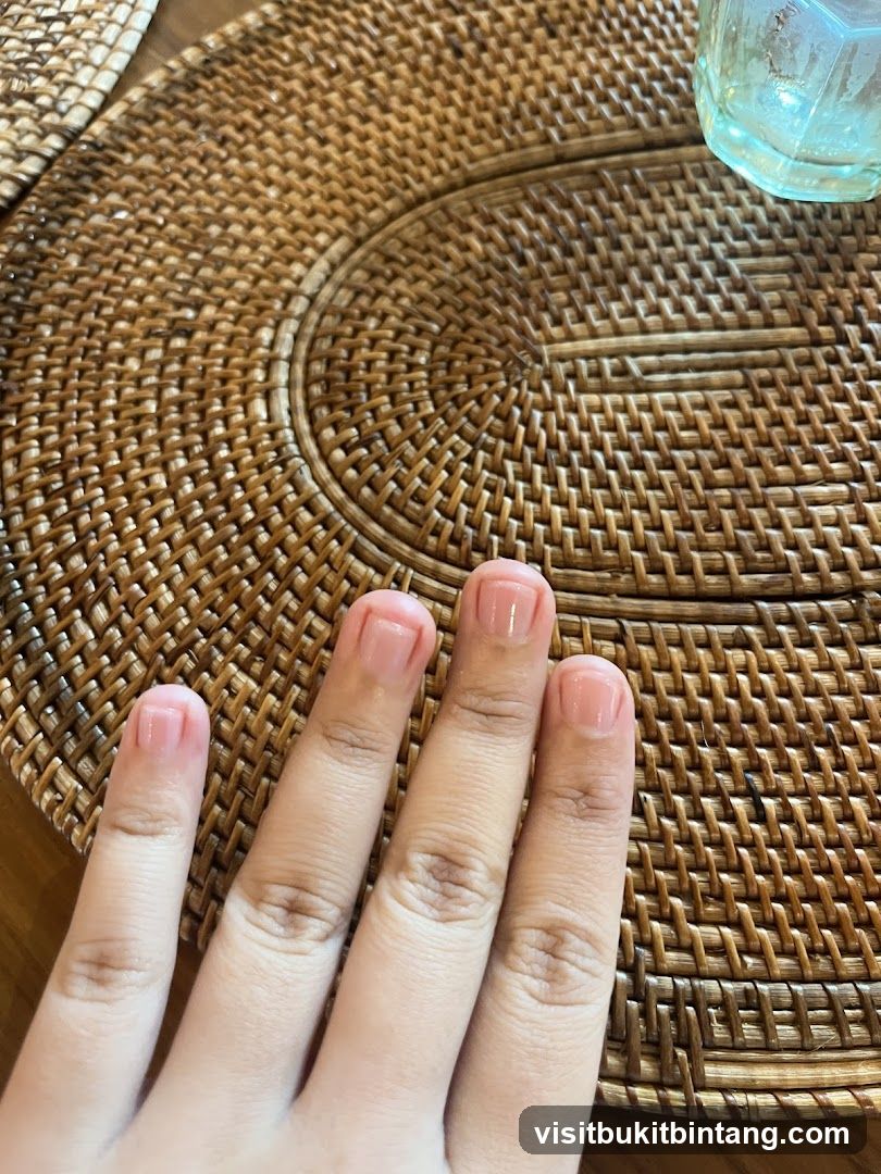 Hand with manicured nails on a woven placemat