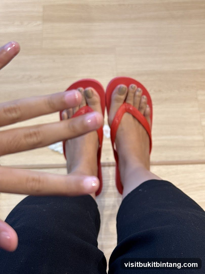 Feet with red flip-flops and painted toenails