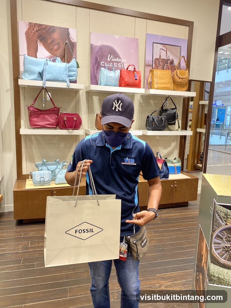 Man holding a Fossil shopping bag