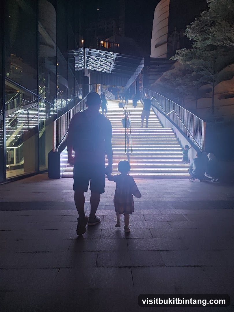 People walking up illuminated stairs at night