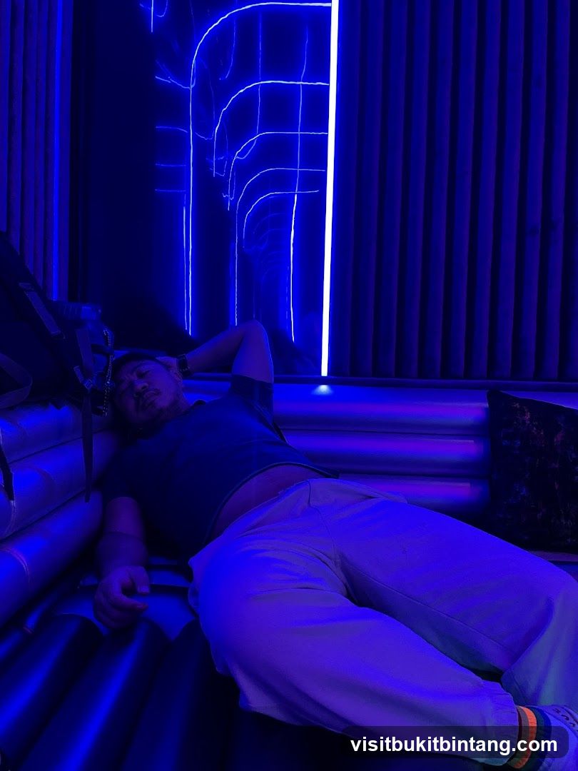 Man resting in a neon-lit room