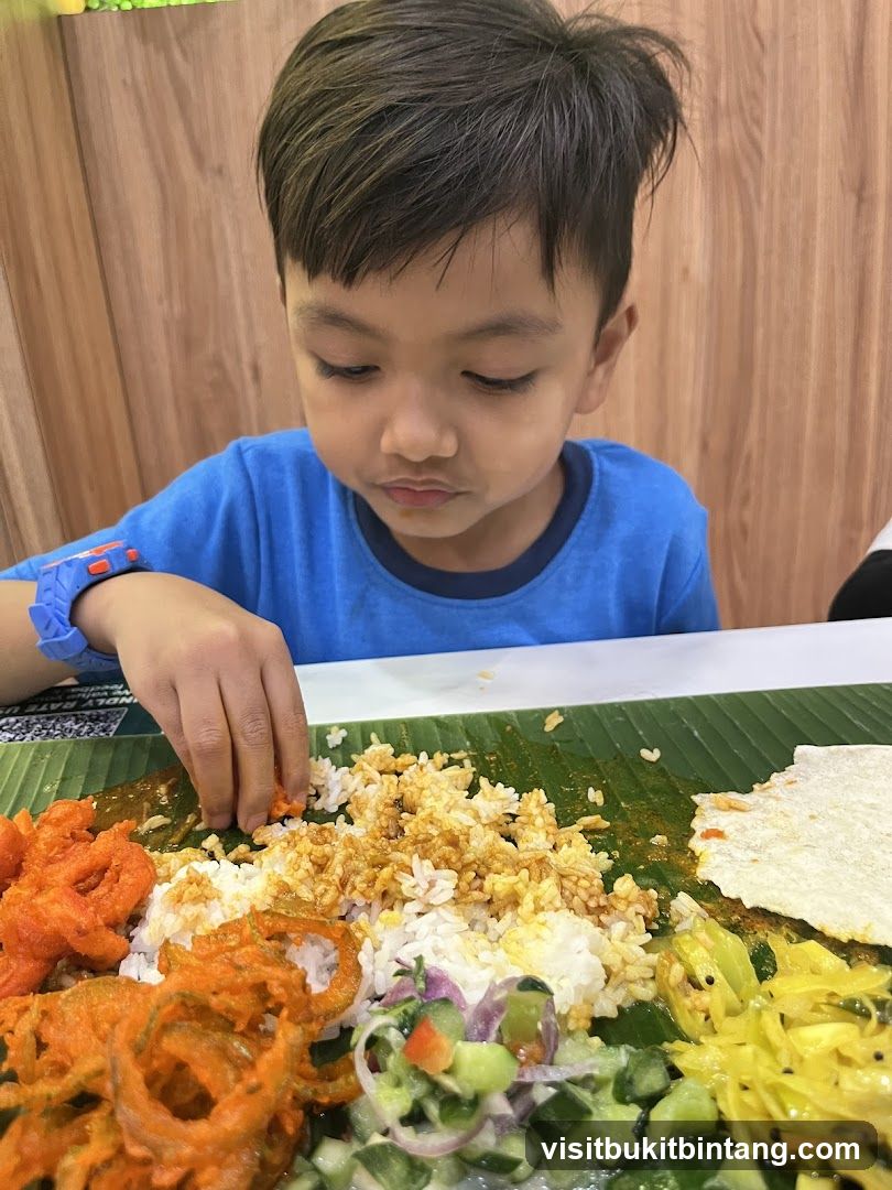 Boy eating a meal served on a banana leaf