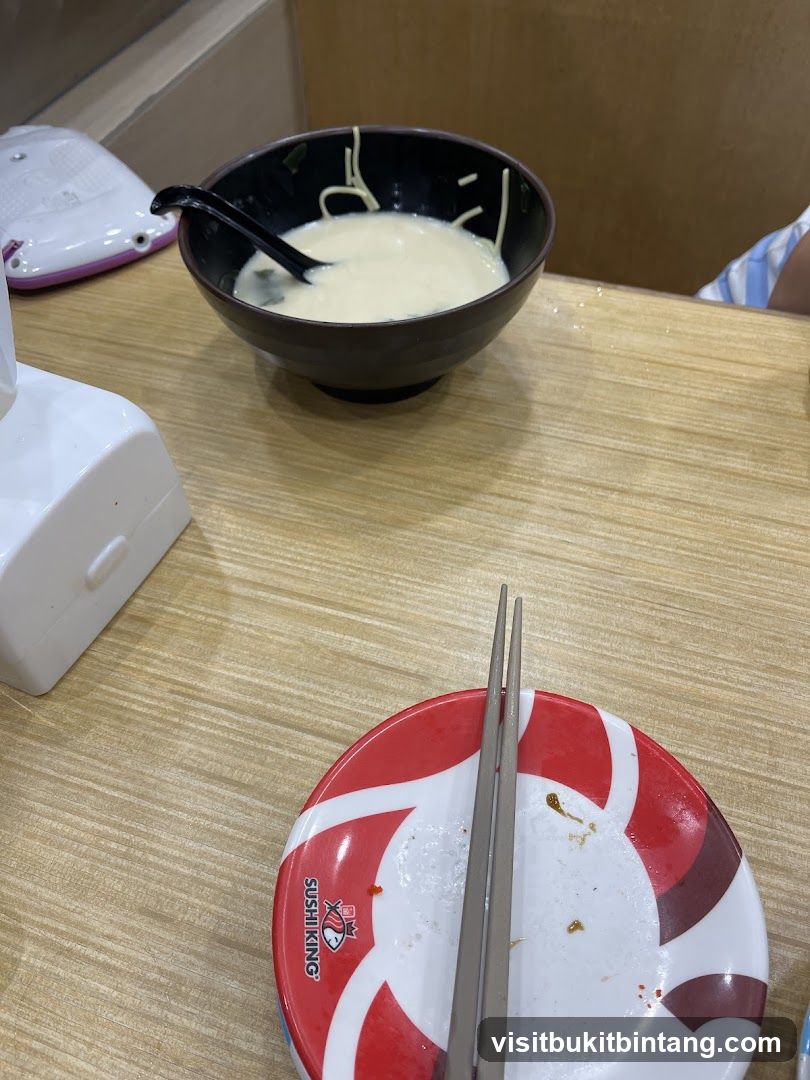 Bowl of noodles with soup and chopsticks on a plate
