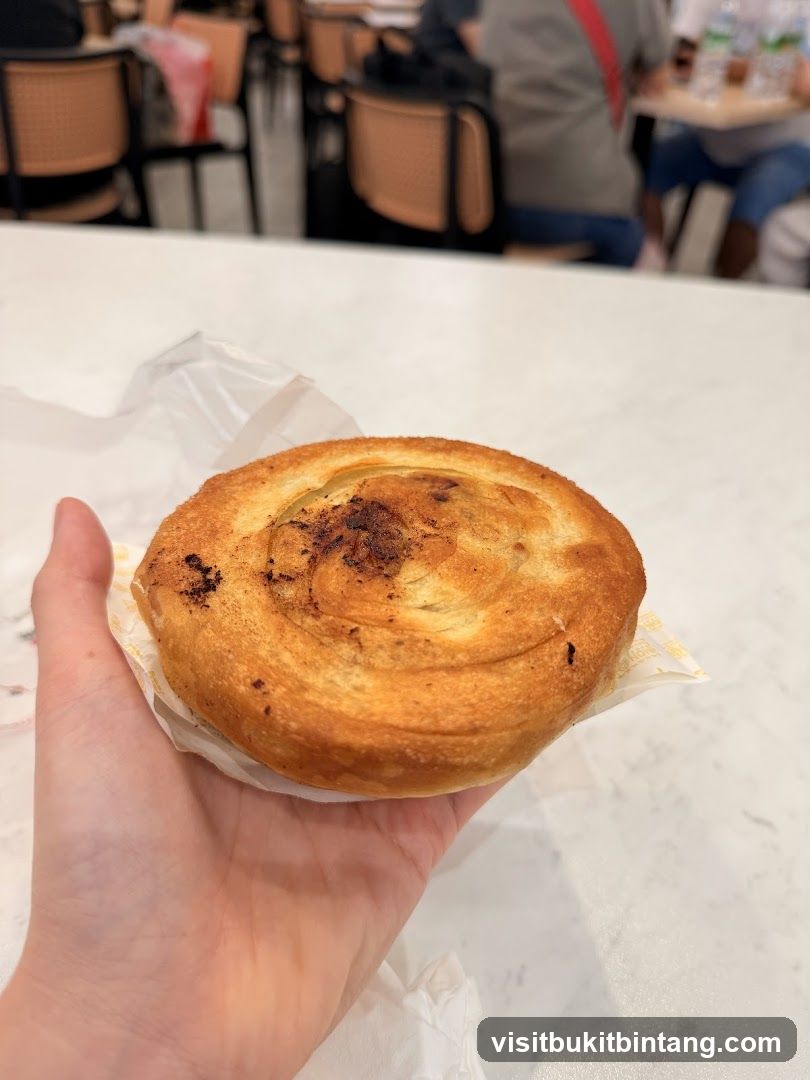Hand holding a pastry in a cafe