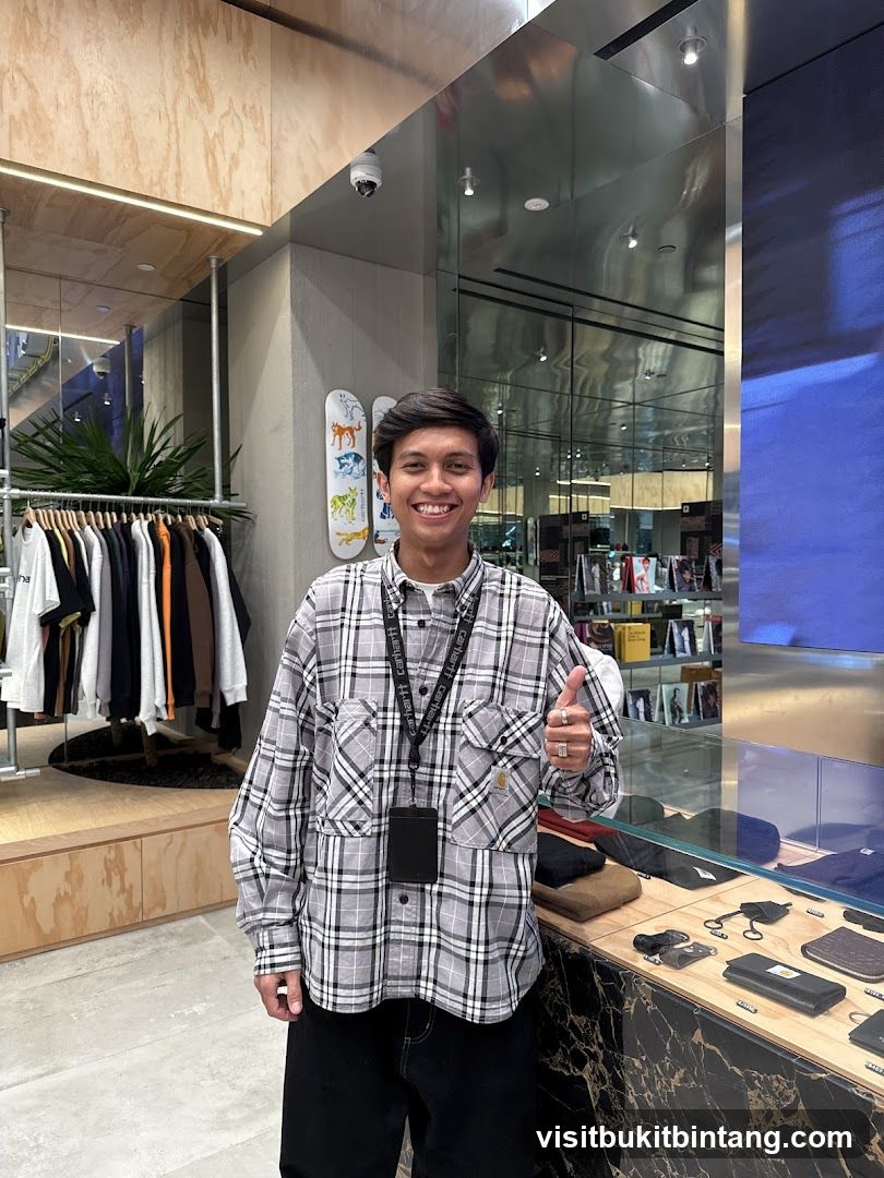 Man in Plaid Shirt Giving Thumbs Up in Store