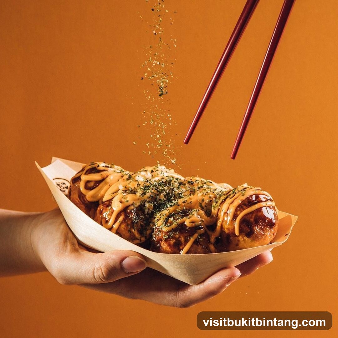 Takoyaki being sprinkled with herbs