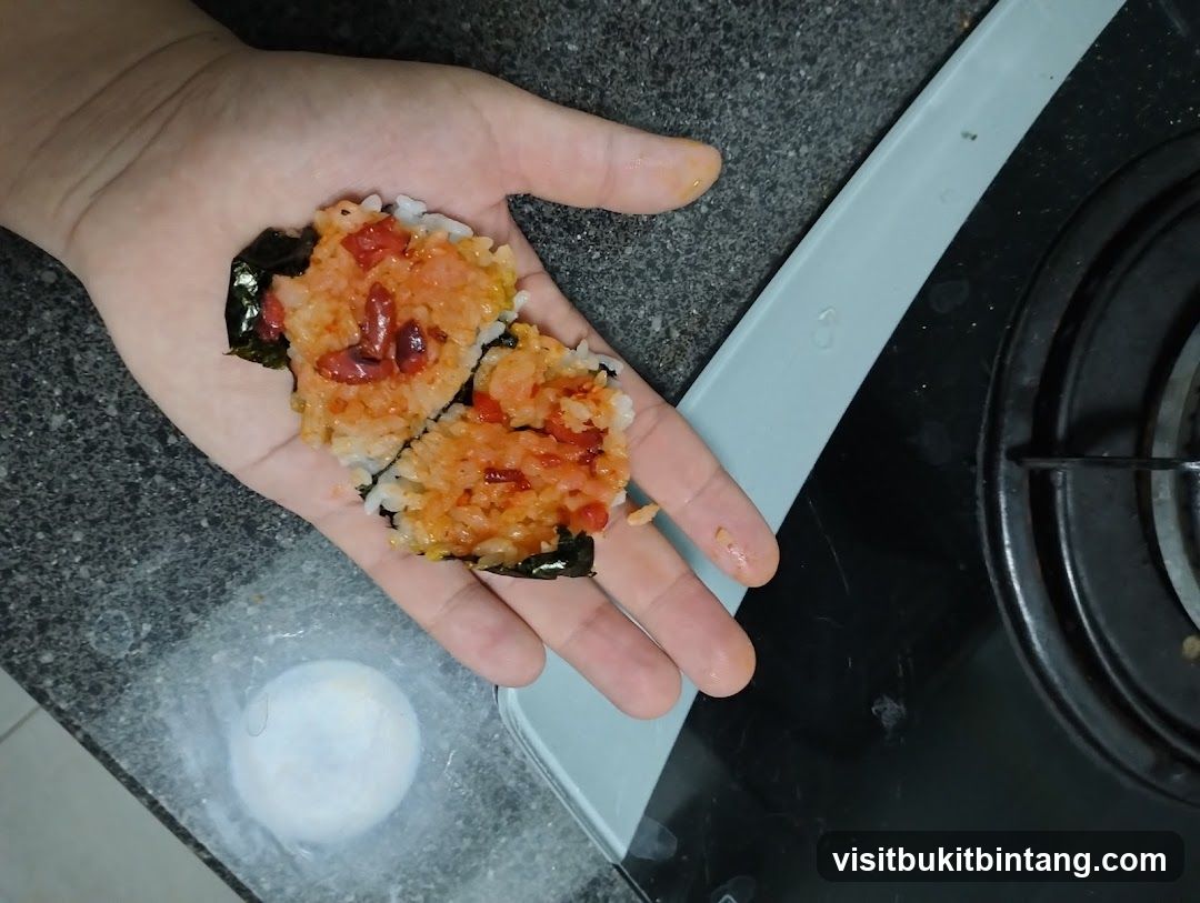Hand holding rice and seaweed mixture
