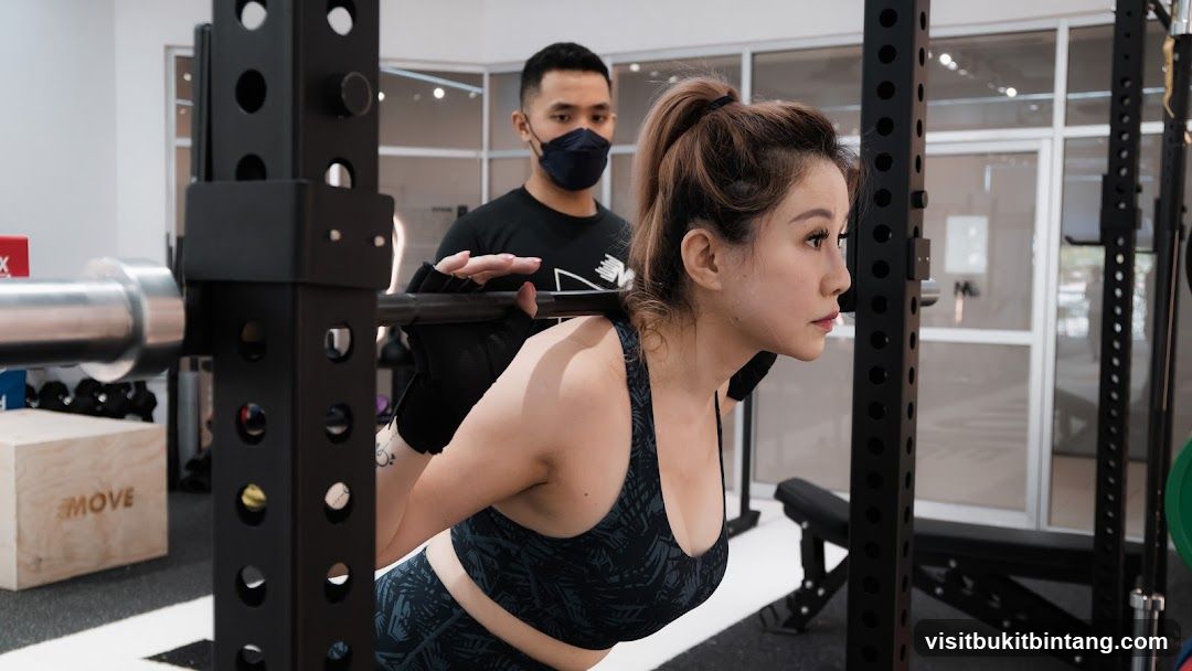 Woman performing squats with trainer