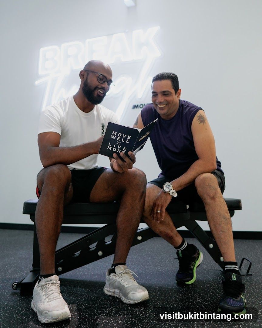 Two men looking at a book in a gym