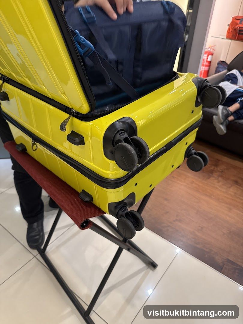 Bright yellow suitcase with a navy blue duffel bag inside