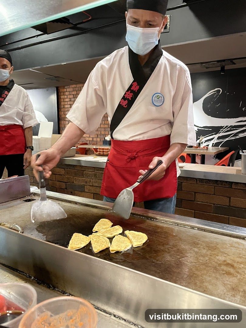 Chefs cooking on a teppanyaki grill