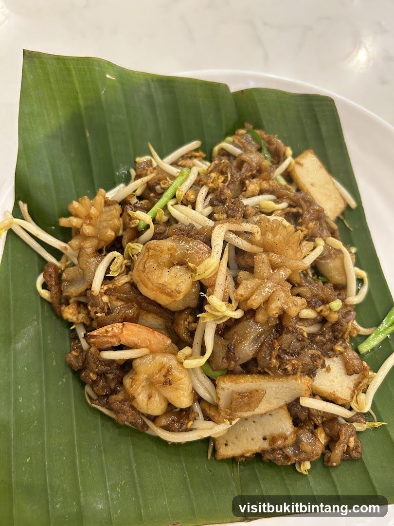 Stir-fried noodles with shrimp and tofu on banana leaf