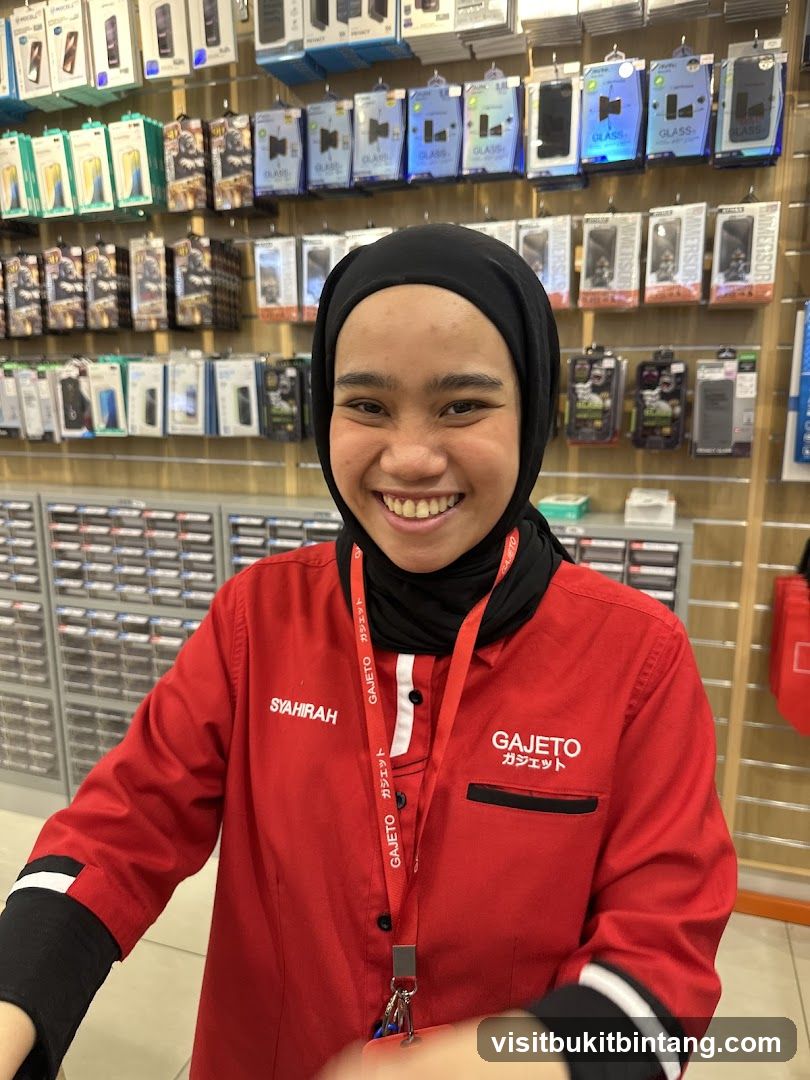 Staff in red uniform smiling at camera