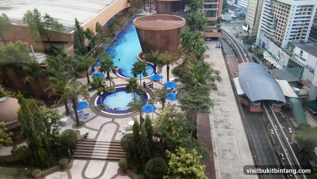 Aerial view of a resort pool area and adjacent highway