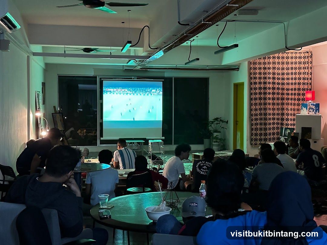 People watching a soccer match on a projector screen