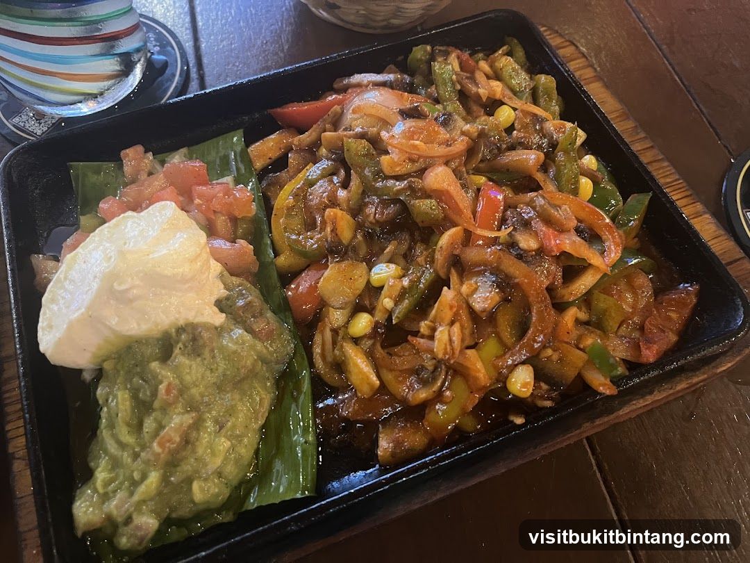 Sizzling Vegetable Dish with Guacamole and Sour Cream