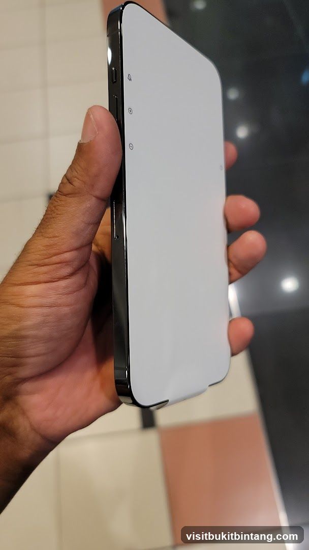 Hand holding a white smartphone with protective case