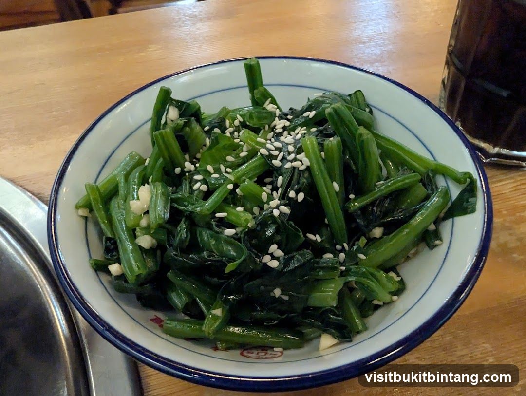 Bowl of stir-fried greens with sesame seeds and garlic