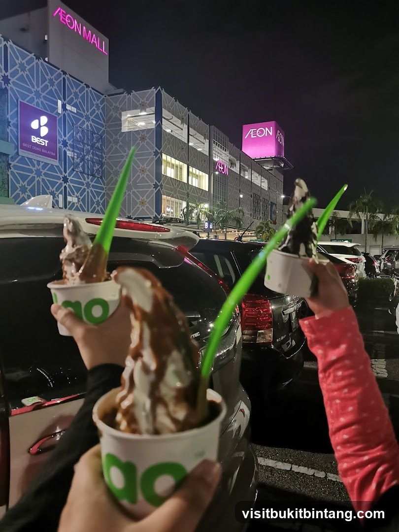 People holding ice cream cups outside a mall
