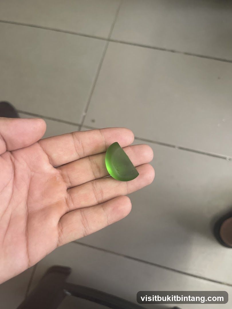 Hand holding green gemstone