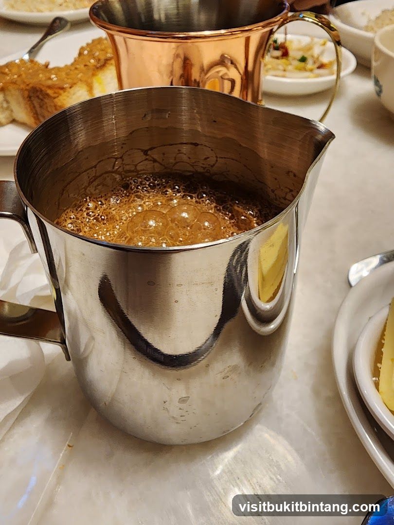 Frothy Coffee in a Metal Pitcher