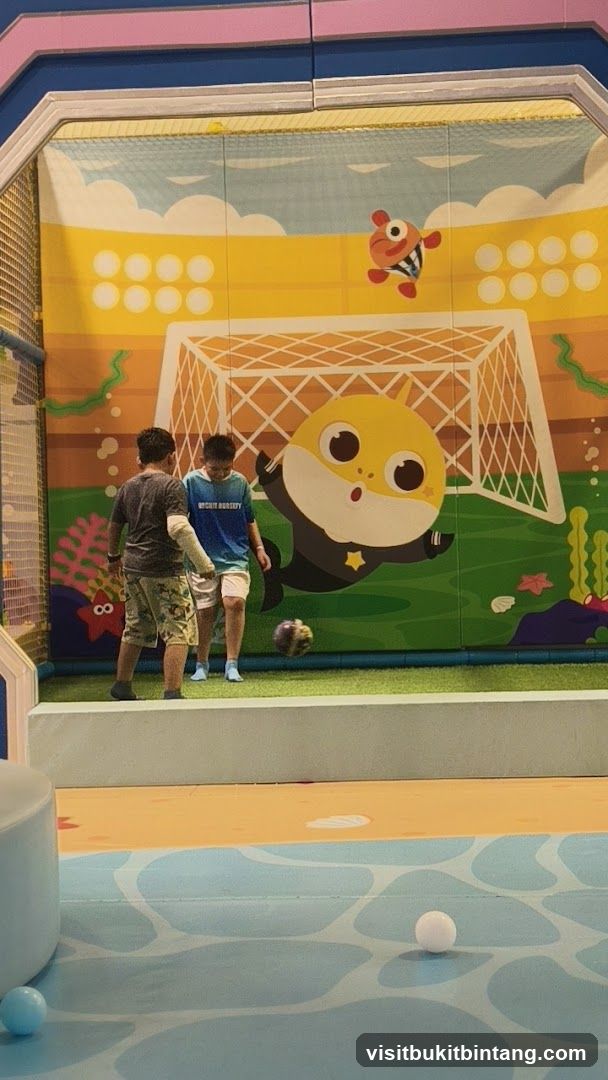 Children playing soccer in a cartoon-themed indoor playground