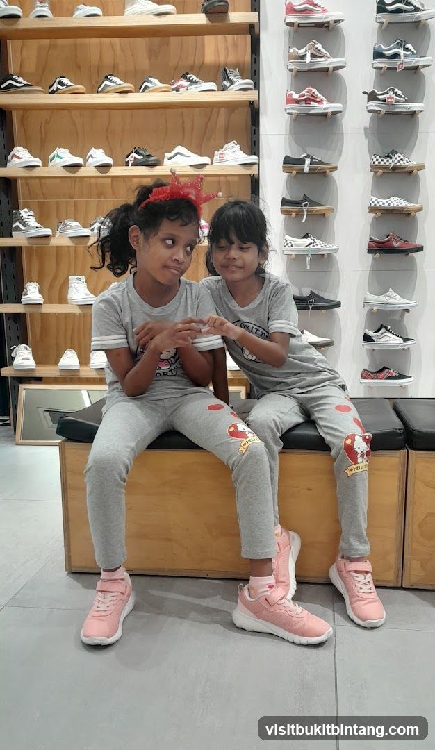 Two girls sitting in a shoe store