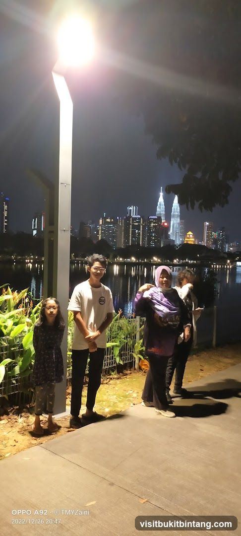 People by a lake at night with city skyline