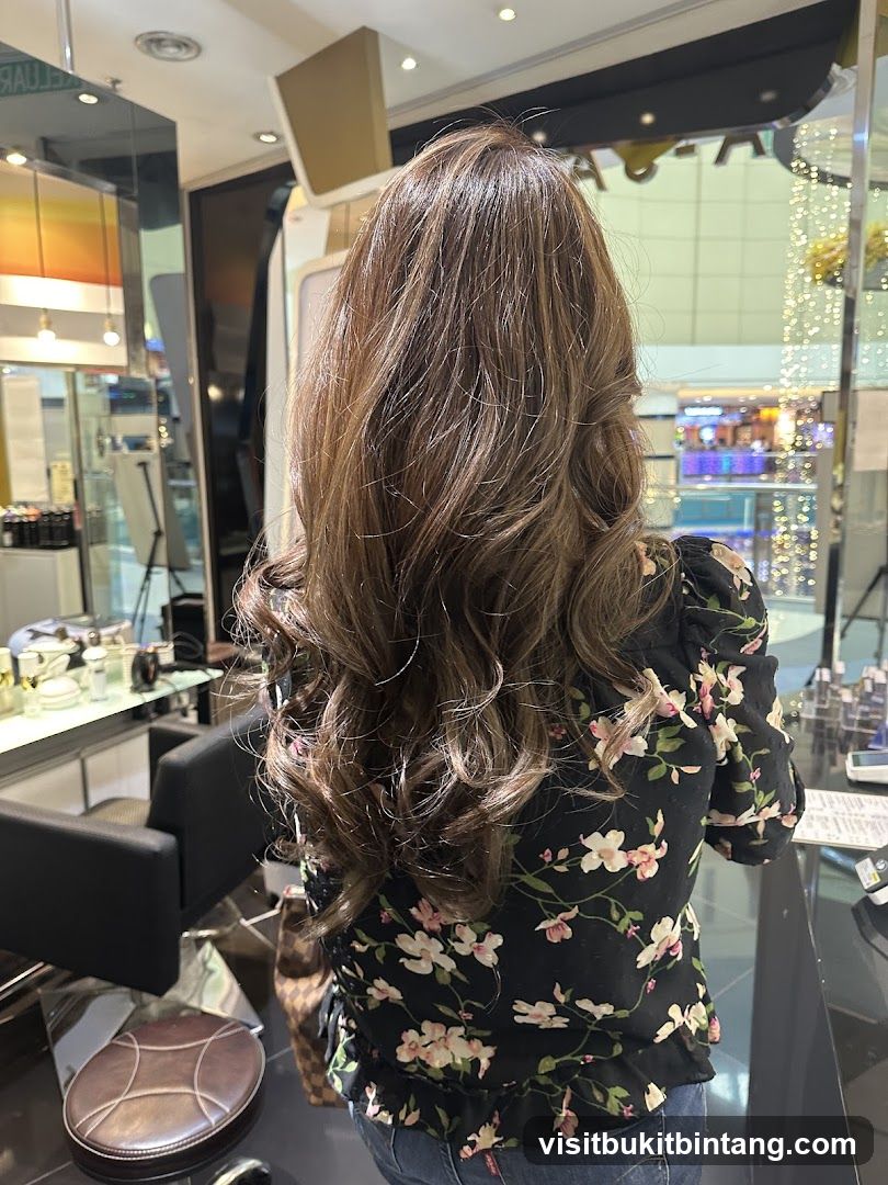 Woman with long, wavy brown hair in a salon