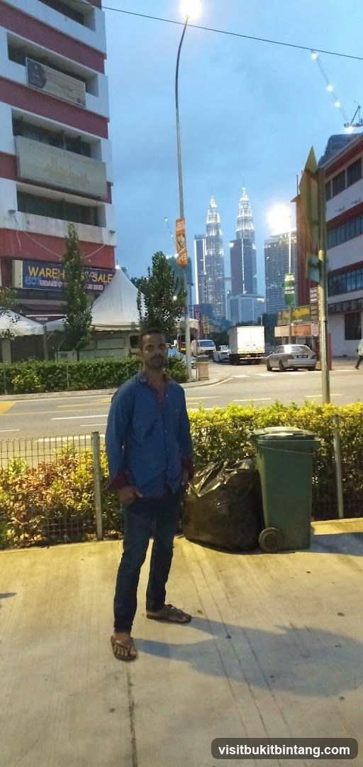 Man standing on sidewalk with city skyline in background