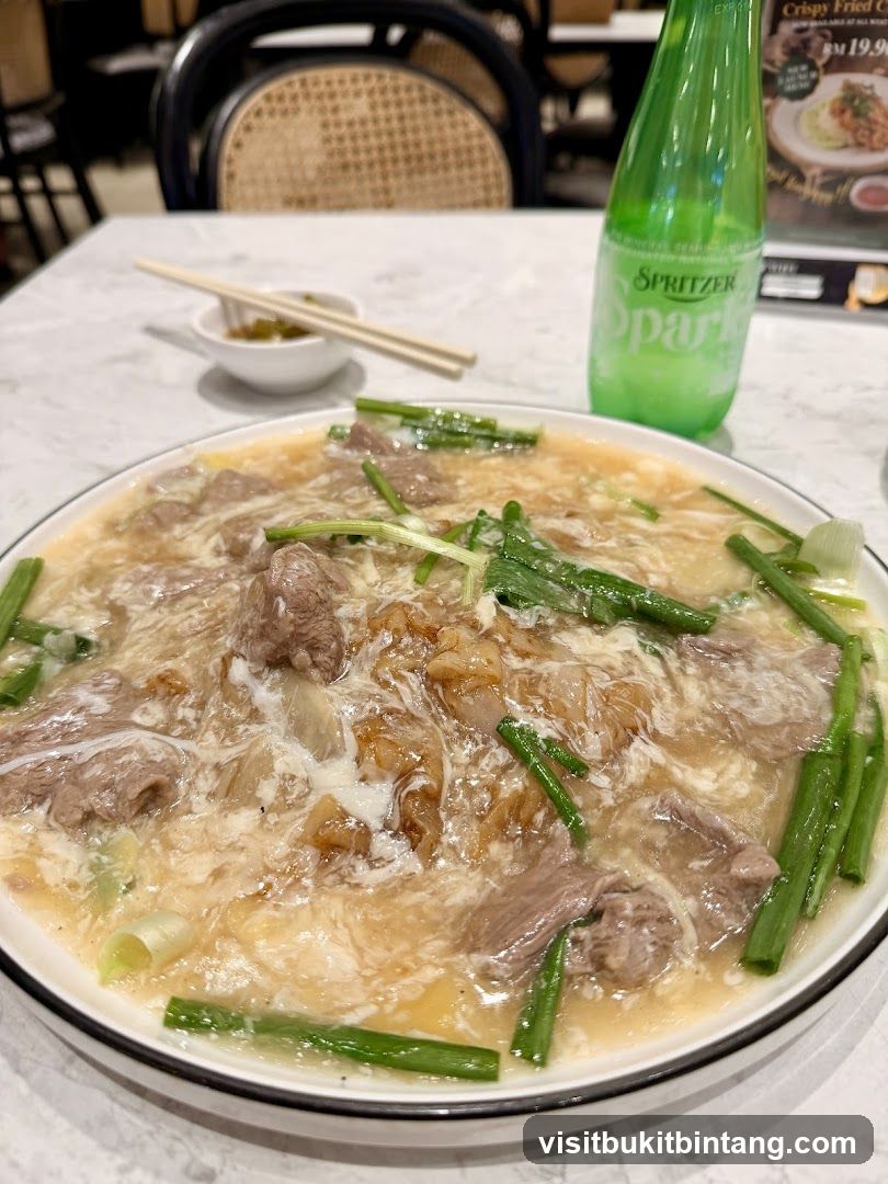 Beef noodle dish with a bottle of sparkling water