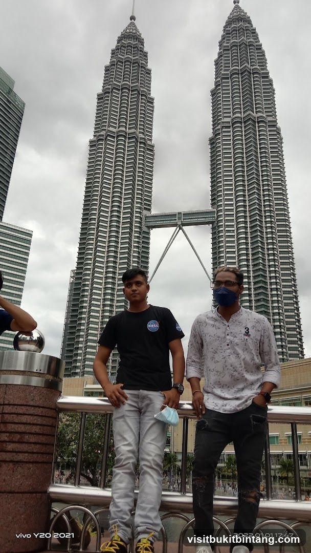 Two men posing in front of the Petronas Towers