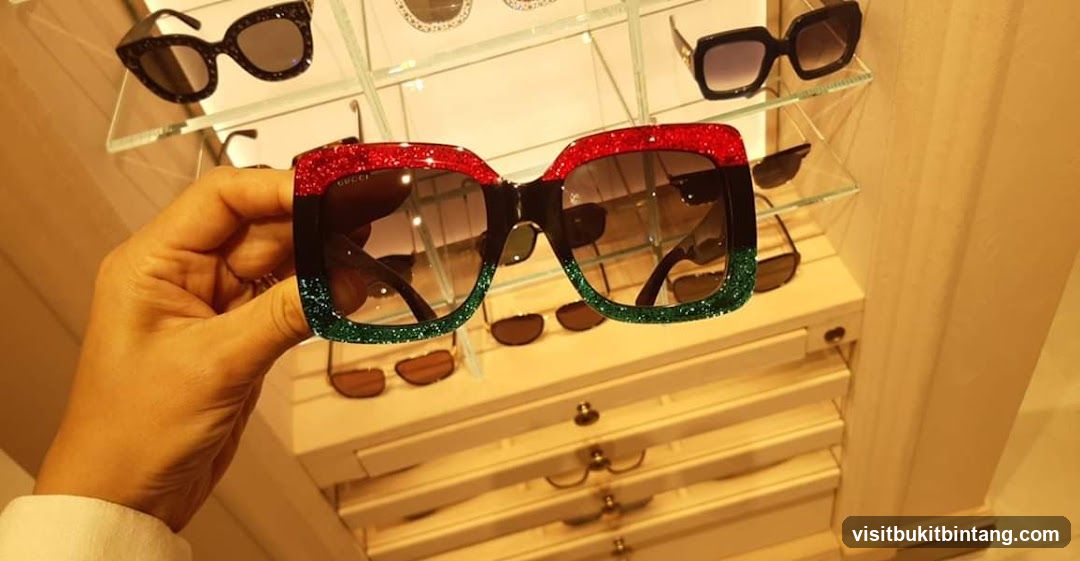 Hand holding Gucci sunglasses
