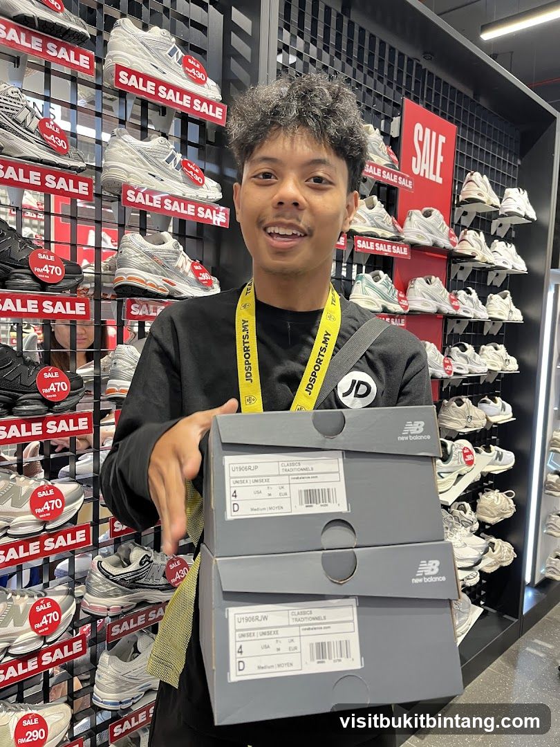 Man holding New Balance shoe boxes in a JD Sports store