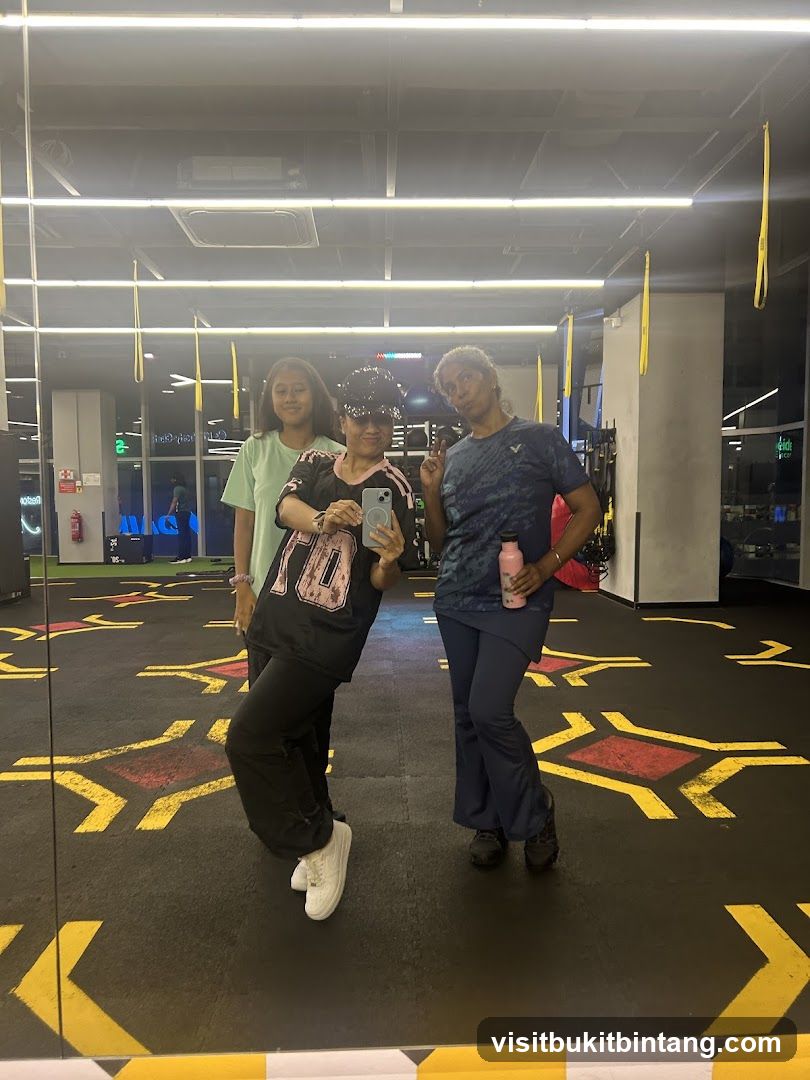 Three people posing for a mirror selfie in a gym