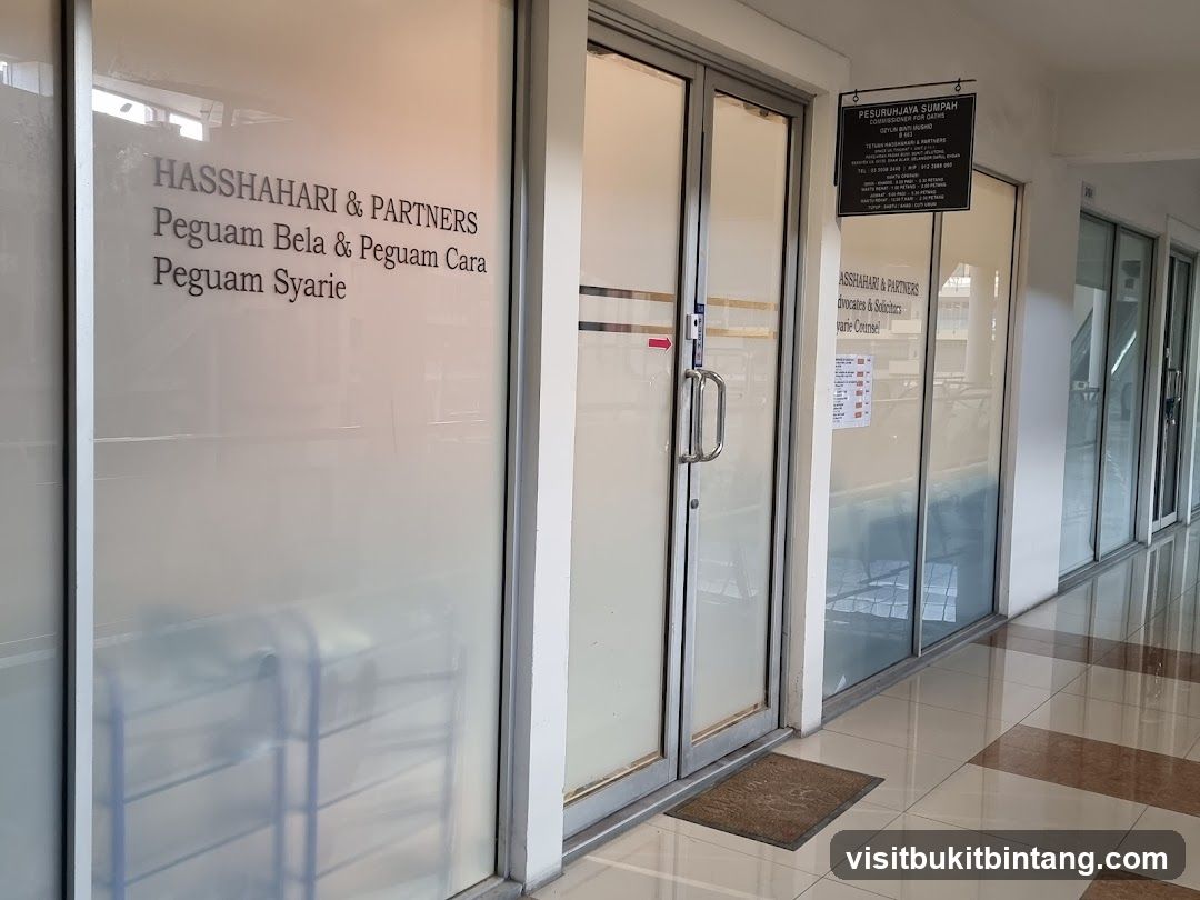The exterior of a law firm with frosted glass doors and windows. The firm's name, "HASSHAHARI & PARTNERS", is visible on the glass. A sign above the entrance reads "PESURUHJAYA SUMPAH COMMISSIONER FOR OATHS".