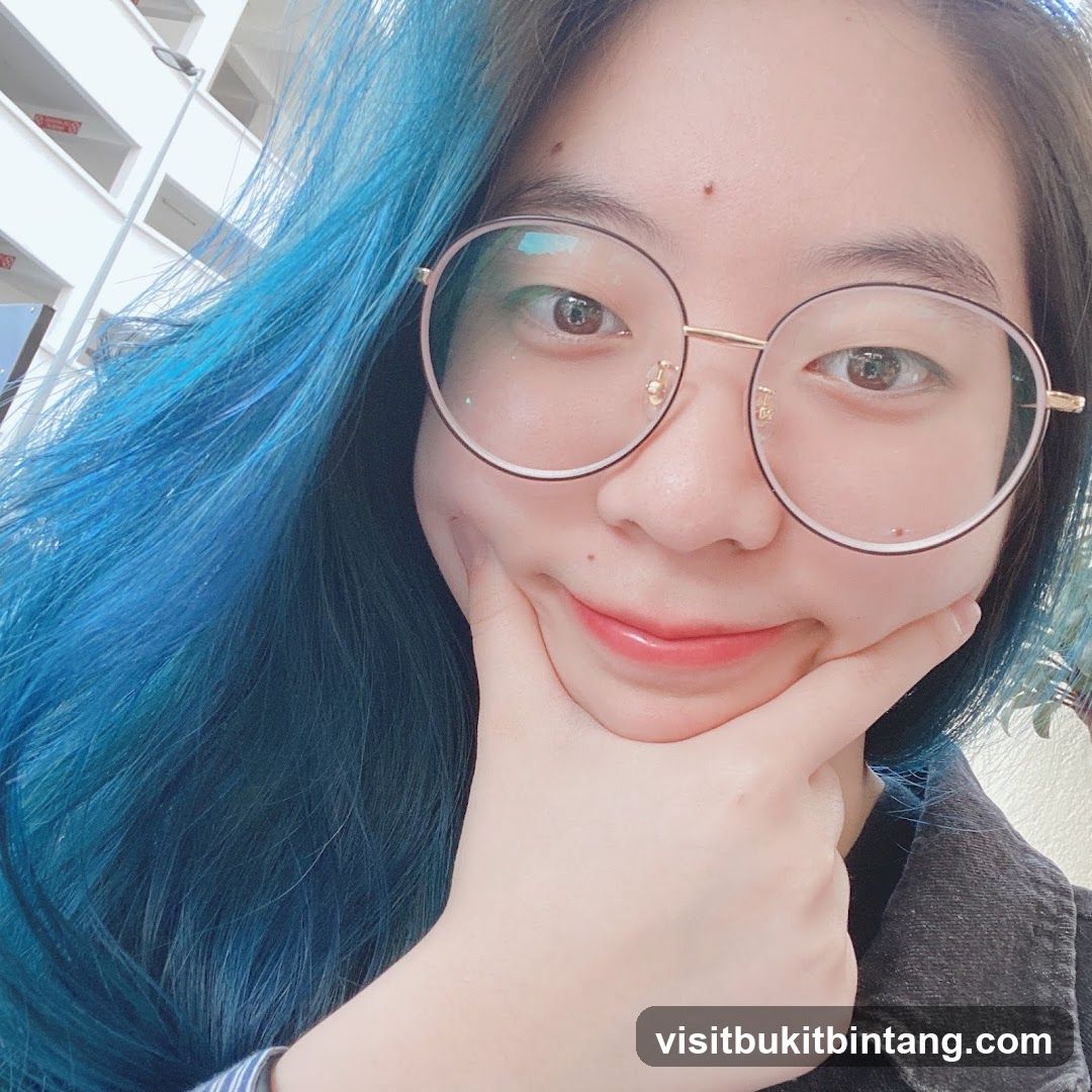 Woman with blue hair and glasses