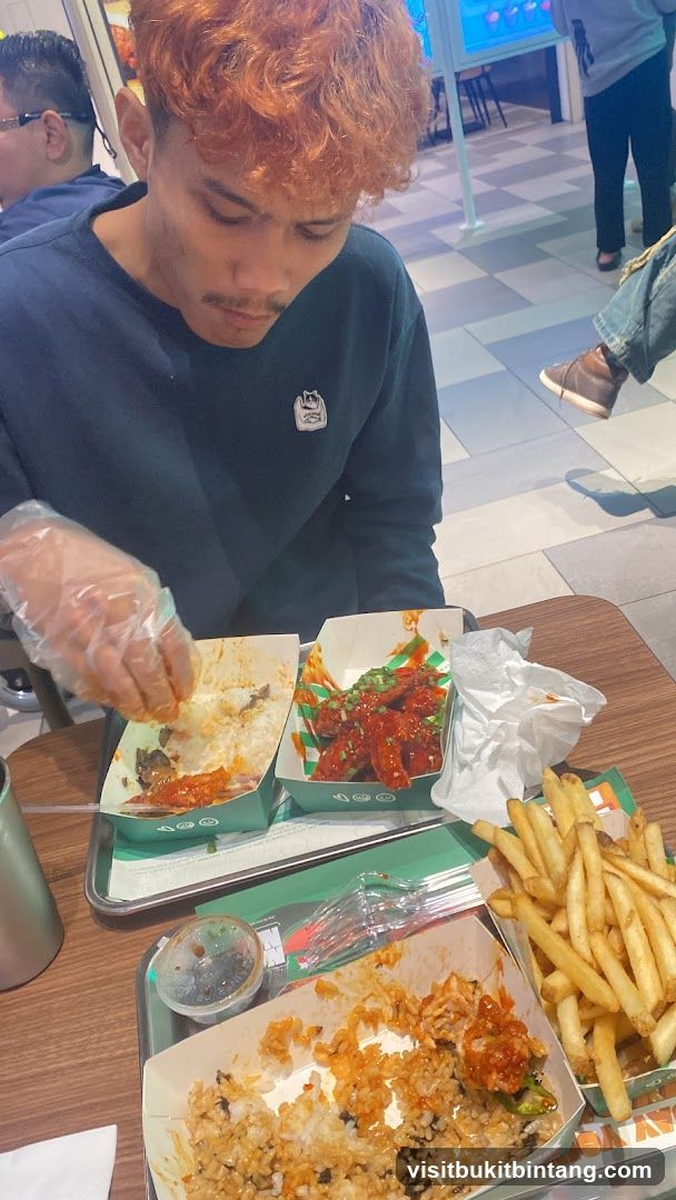 Person eating fried chicken and rice