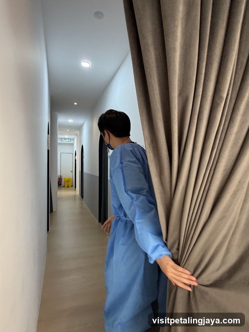 Person in blue gown pulling curtain