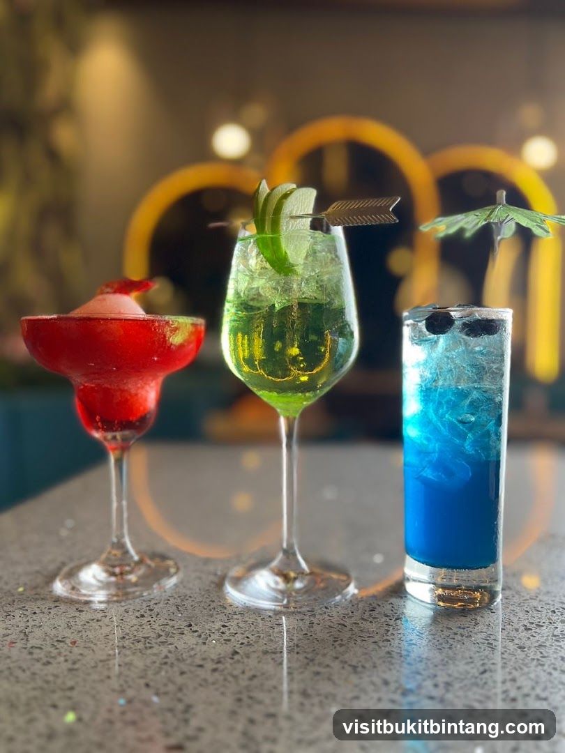 Three colorful cocktails on a bar counter
