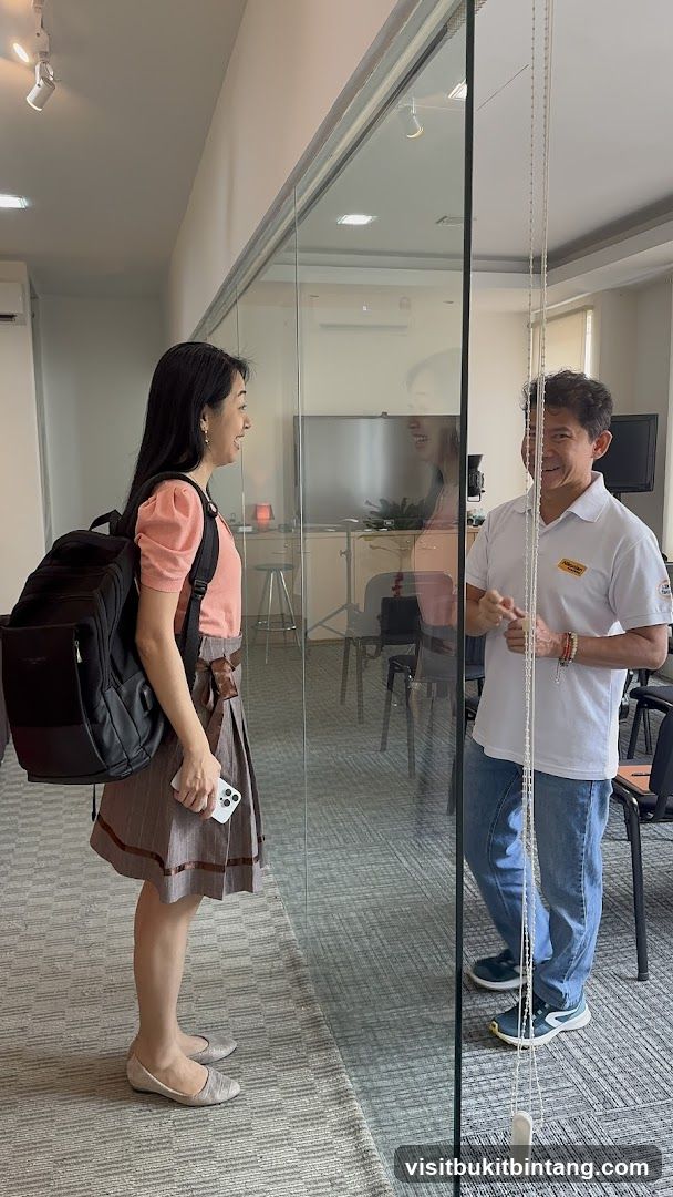 Two people talking through a glass partition