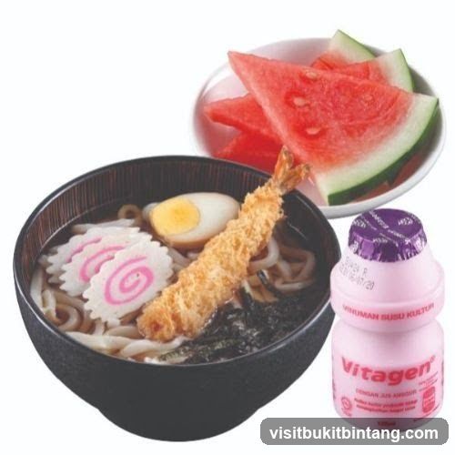 Udon noodles with tempura shrimp, egg, fish cake, seaweed, watermelon, and a bottle of Vitagen yogurt drink.