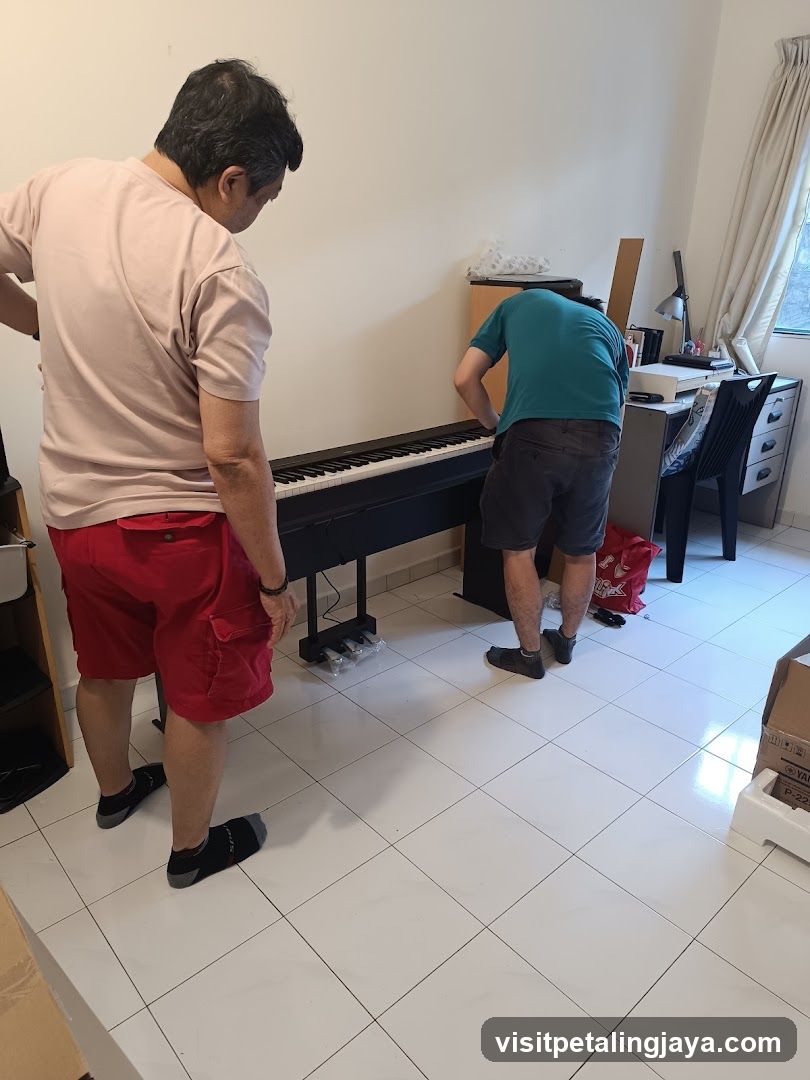 Two men assembling a digital piano in a room