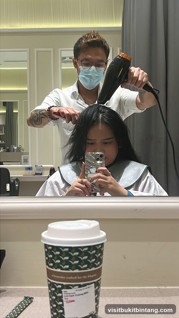 Hairdresser drying client's hair